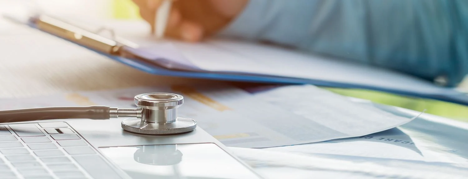 Medical billing documents, insurance claim forms and a laptop — healthcare revenue cycle management in practice