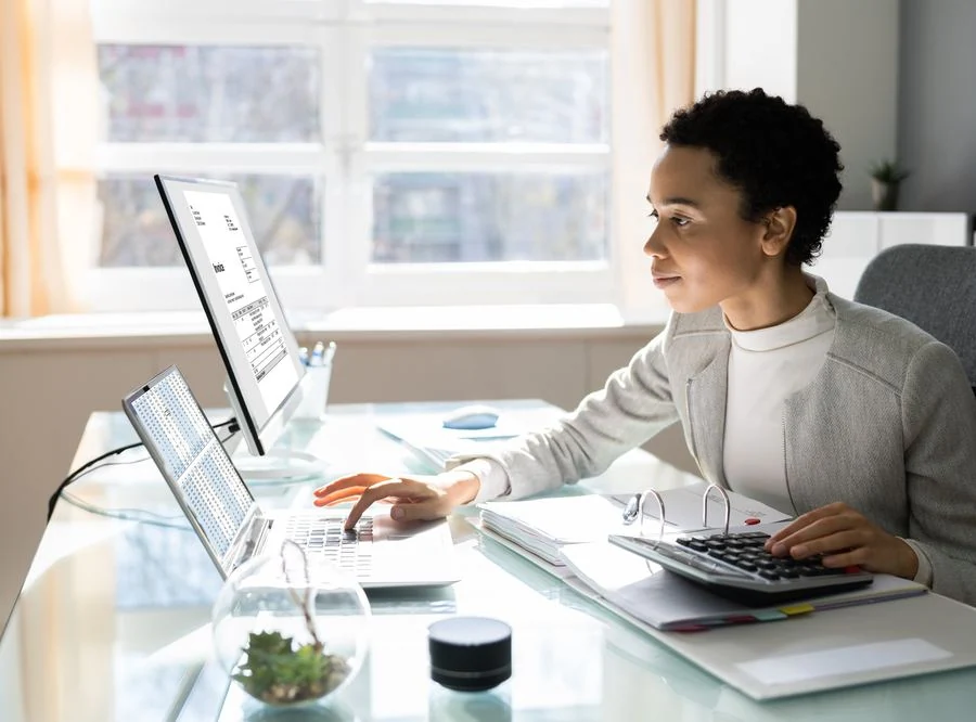 Billing specialist reviewing invoices and aged accounts receivable on screen